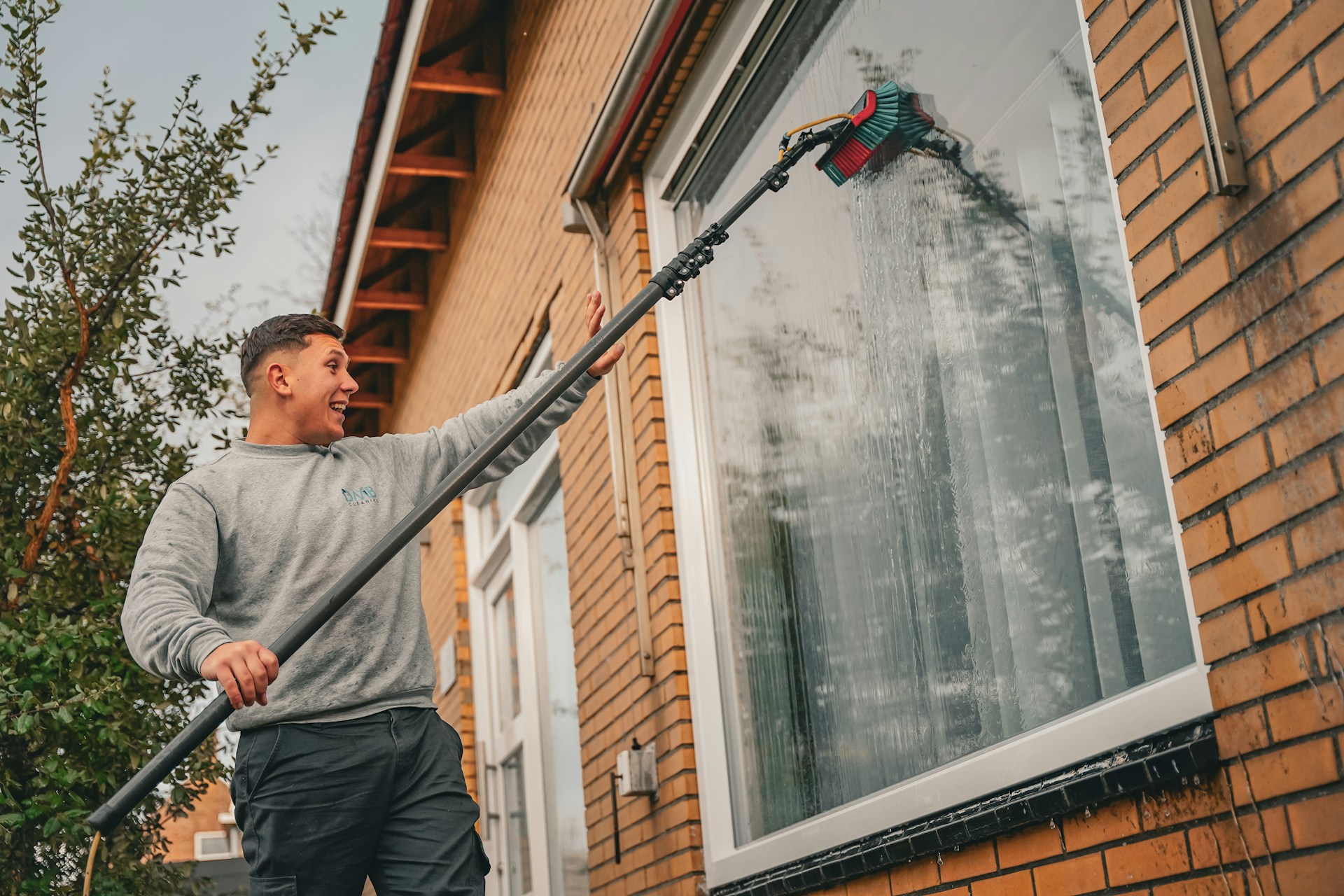 Professionnel nettoyant une grande fenêtre